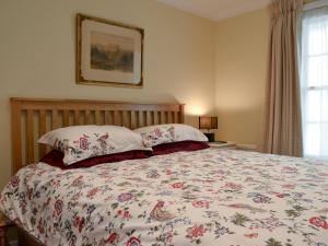 雅克萨穆古宅小木屋的一间卧室配有一张带花卉床罩的大床