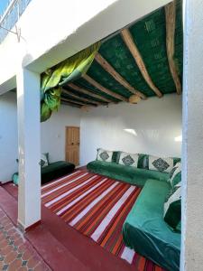 马拉喀什Riad Mama Toutou的一间铺有地毯的带两张绿色床的客房