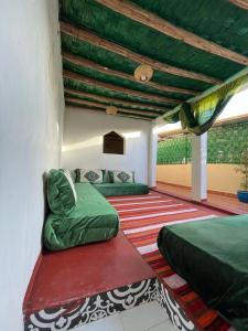 马拉喀什Riad Mama Toutou的一间卧室设有两张床和绿色的天花板