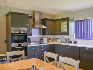 DoddingtonLucys Lodge - Ukc2202的厨房配有蓝色橱柜和桌椅