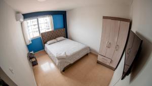 巴拿马城Blu Hostel的一间小卧室,配有床和窗户