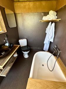奥本罗Krusmølle Glamping的带浴缸、卫生间和盥洗盆的浴室