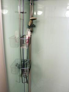 SparreholmTwister 53的浴室设有玻璃门,配有篮子和架子