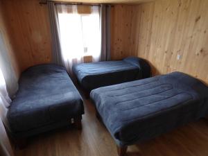 PueloCabañas Austral Rivers的一间卧室设有两张单人床和一个窗户。