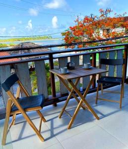 凯鲁Pousada Atracadouro Boipeba的阳台上配有一张木桌和两把椅子