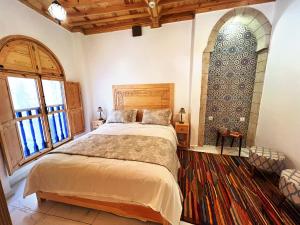 索维拉Riad Al Manara的一间卧室设有一张大床和一个大窗户