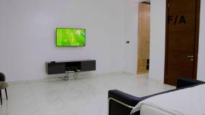 伊凯贾Favourite Luxury 2 Bedroom Apartment的一间客厅,在白色的墙上配有电视