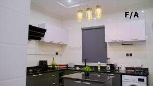 伊凯贾Favourite Luxury 2 Bedroom Apartment的厨房配有白色橱柜和黑色台面