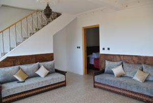 Ferme Dar Aicha green Bellouta的客厅设有两张沙发和一个楼梯