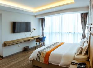 利马Gold Source Hotel的酒店客房配有一张床、一张书桌和一台电视。