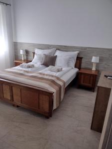 KápolnásnyékTandem apartman的一间卧室配有一张带2个床头柜的大床