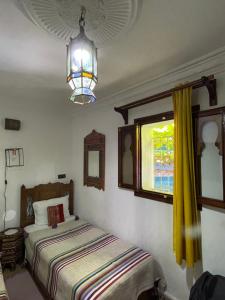 舍夫沙万达尔萨巴巴摩洛哥传统庭院住宅旅馆的一间卧室设有两张床和窗户。