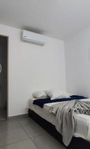 圣贝尔纳多德尔比恩托Apartamento 201 Palmar de los vientos的卧室配有一张白色墙壁的床