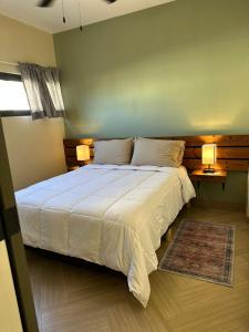 恩塞纳达港Habitación 23 - Green Casitas的一间卧室配有一张带两盏灯的大型白色床。