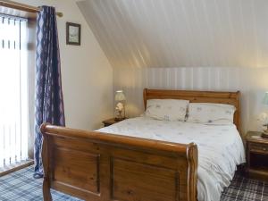 UplawmoorOld Stable Cottage的一间卧室配有一张带木制床架的床