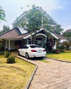 巴图Villa Dedaun Batu的停在房子前面的白色汽车
