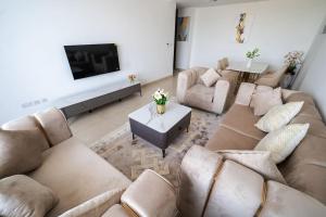 迪拜Elegant 2BR near Palm Jumeirah - 6 Min Drive的带沙发和电视的大型客厅