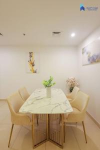 迪拜Elegant 2BR near Palm Jumeirah - 6 Min Drive的餐桌、椅子和白色桌子