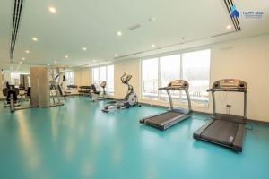 迪拜Elegant 2BR near Palm Jumeirah - 6 Min Drive的一间健身房,铺有蓝色地板,配有健身器材