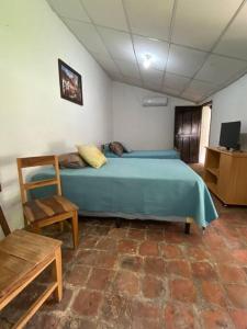 SuchitotoCasa Colonial的一间卧室配有蓝色的床和椅子