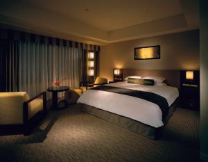 京都Hotel Okura Kyoto的酒店客房带一张大床和一把椅子
