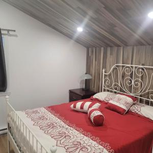Saint-PaulinLe Jasmin chalet complet Rivière Kayak Nature的卧室配有红色和白色的床和枕头