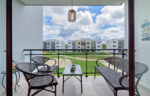 蓬塔卡纳Lujoso apartamento con piscina cerca de la playa的设有一个配有桌椅并享有美景的阳台。