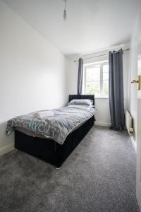 梅德斯通Maidstone villa 3bedroom free sports channels park的一间卧室设有一张大床和窗户