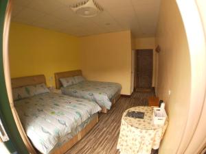尖石乡泰崗崗好山莊的一间小卧室,配有两张床和一张桌子