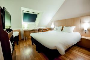 瓦讷宜必思瓦纳酒店的一张大白色的床,位于酒店客房内
