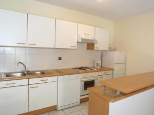 莱热Appartement Les Gets, 3 pièces, 8 personnes - FR-1-671-86的厨房配有白色橱柜和水槽
