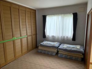 富良野FURANO UEDA HOUSE的客房设有两张床和窗户。