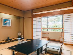 松江市玉泉酒店的一间带桌椅和窗户的用餐室