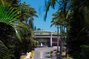 努美阿努美阿子午线度假酒店及Spa的一座拥有喷泉和棕榈树的建筑