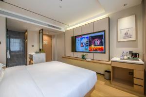 义乌义乌百德主题酒店的卧室配有一张白色大床和一台平面电视。