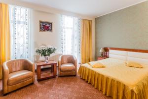 布加勒斯特安菲特律翁酒店的酒店客房,配有一张床和两把椅子