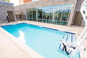 安大略SpringHill Suites by Marriott Ontario Airport/Rancho Cucamonga的大楼前带椅子的游泳池