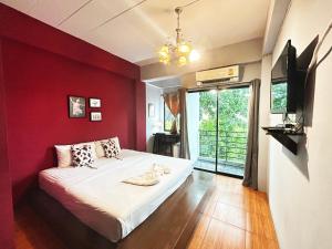曼谷隐逸曼谷旅舍的卧室设有红色墙壁、一张床和一个窗户