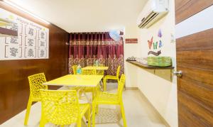 马杜赖Treebo Trend D Grand的用餐室配有黄色桌子和黄色椅子