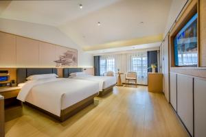 义乌义乌百德主题酒店的酒店客房设有两张床和电视。