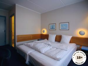 马斯塔尔Ærø Hotel - Adults only的一间卧室配有一张带白色床单的大床