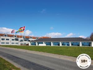 马斯塔尔Ærø Hotel - Adults only的道路前有两面旗帜的建筑物