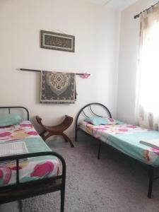 瓜拉弄宾Roomstay homestay Ahmad Rompin的客房设有两张床和窗户。