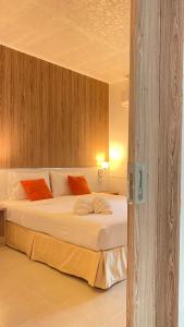 Ban Pak NamLaemsing Natural Beach Resort的一间卧室配有带白色床单和橙色枕头的床。