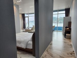 丽水市Suite Stay Yeosu的一间卧室配有一张床,享有海景