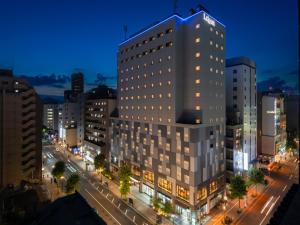 札幌北海道札幌大通柔婕阁酒店的夜幕降临的城市街道上一座高楼