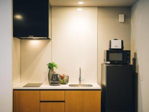 京都MIMARU SUITES KYOTO SHIJO的厨房配有水槽和冰箱