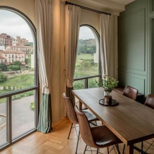 慕斯Toscana Piazza的一间带桌子和大窗户的用餐室
