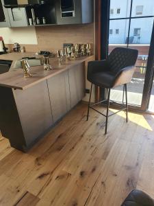 菲拉赫Luxury - Loft的一间铺有木地板的厨房和一把椅子