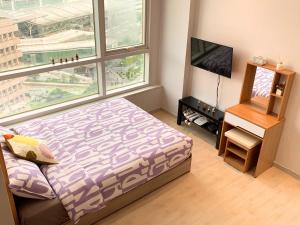 首尔旅行者之家酒店的一间卧室设有一张床、一台电视和一个窗口。